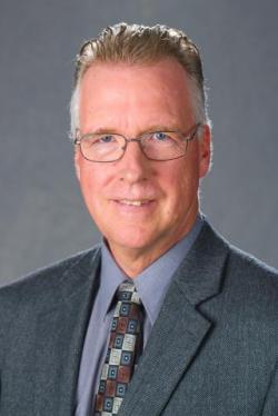 A headshot of David Horohov against a gray background