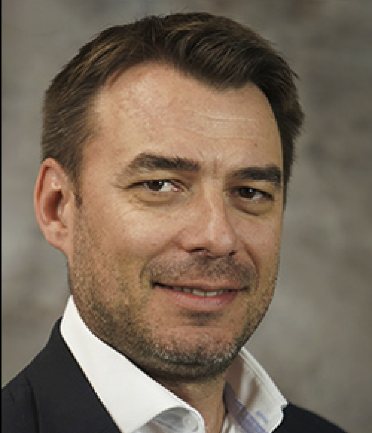 A headshot of Diego Diel against a gray background.